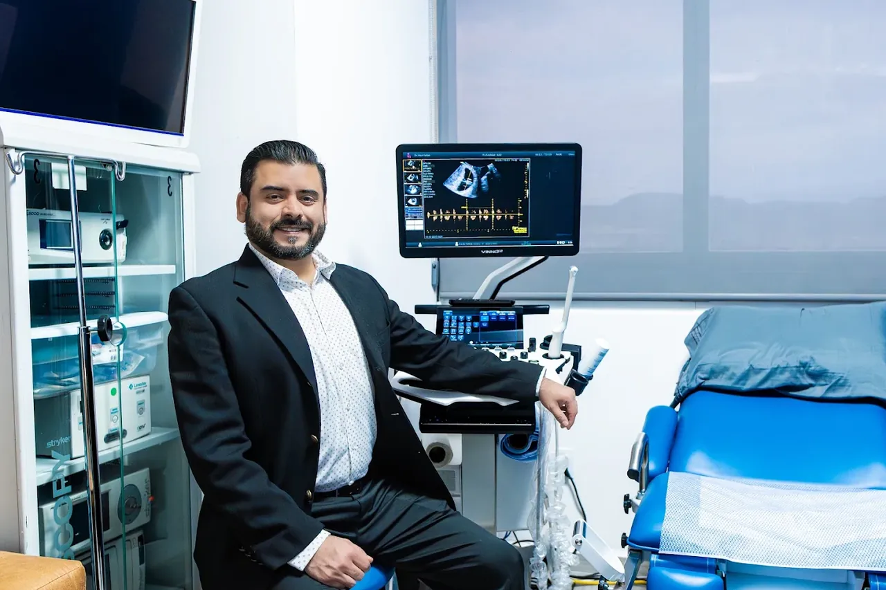Dr. Ra&uacute;l Patl&aacute;n en su consultorio, junto al ultrasonido y la mesa de exploraci&oacute;n