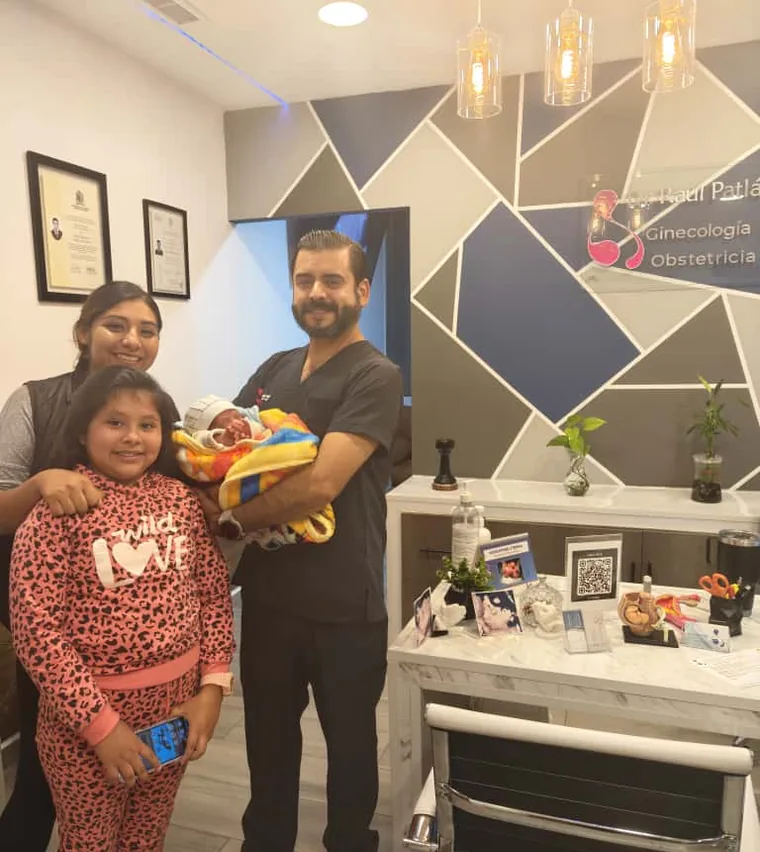 Dr. Raúl Patlán con una familia y su bebé recién nacido en su consultorio de ginecología en León