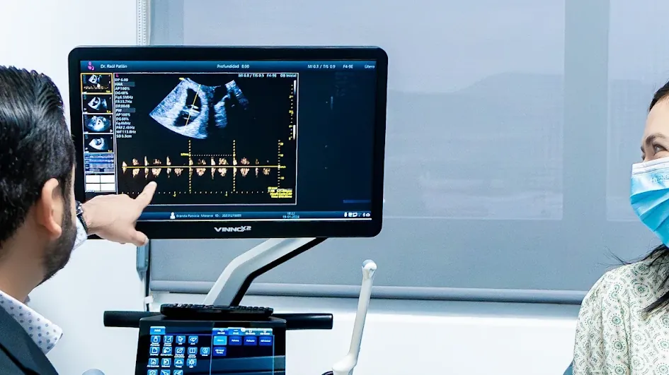 El Dr. Ra&uacute;l Patl&aacute;n explica a la paciente las im&aacute;genes del ultrasonido